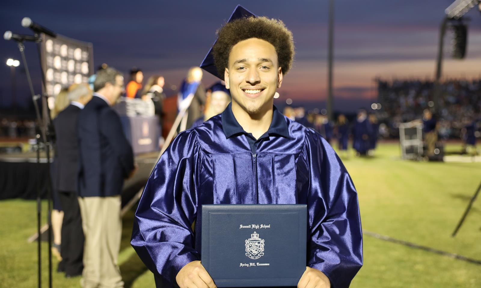 A student holds a diploma
